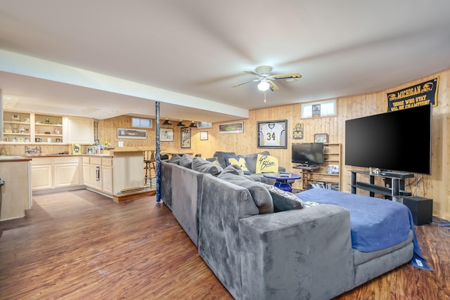 living room featuring wooden walls, dark hardwood / wood-style floors, and ceiling fan