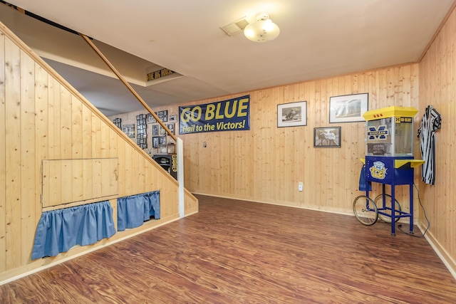 basement featuring dark wood-type flooring and wood walls