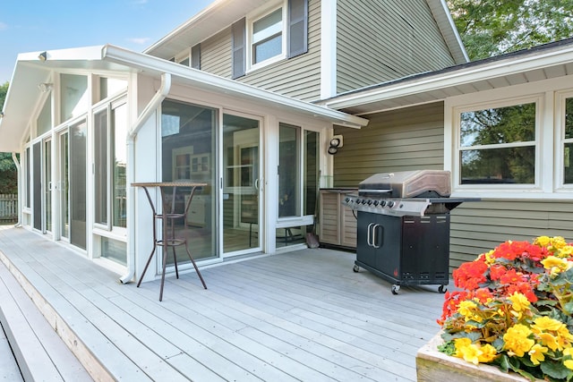 wooden deck with area for grilling and a sunroom