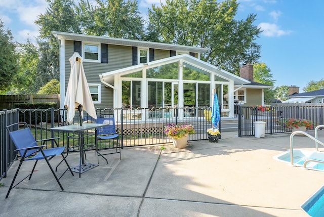 back of property with a swimming pool side deck and a patio