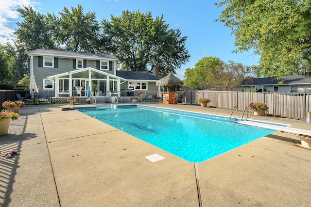 view of pool featuring an outbuilding, a diving board, and a patio