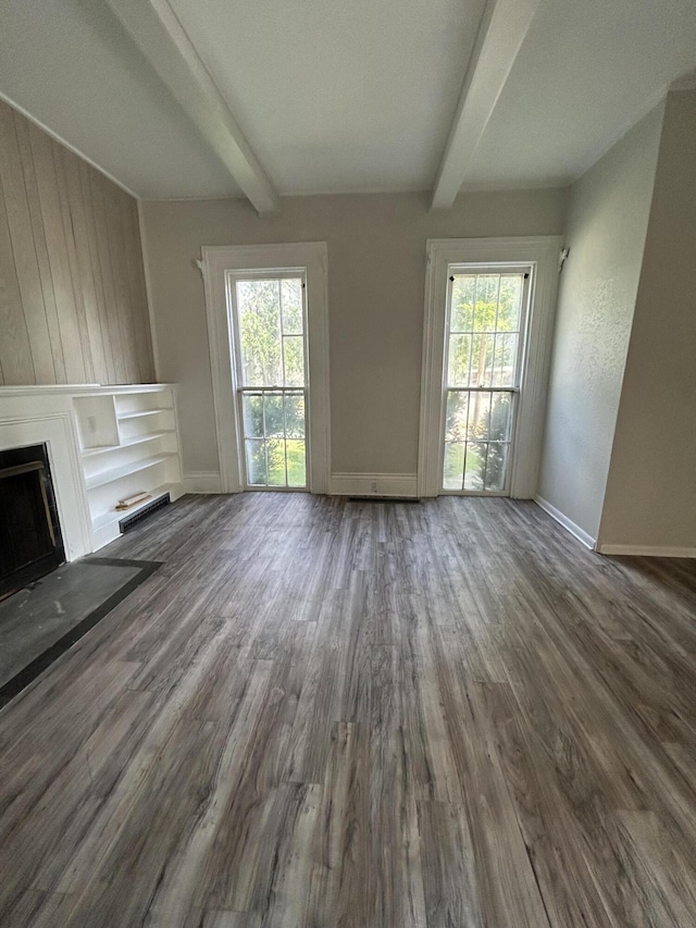 unfurnished living room with wood-type flooring and beam ceiling