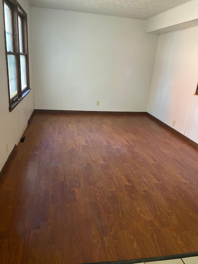 empty room featuring dark wood-type flooring