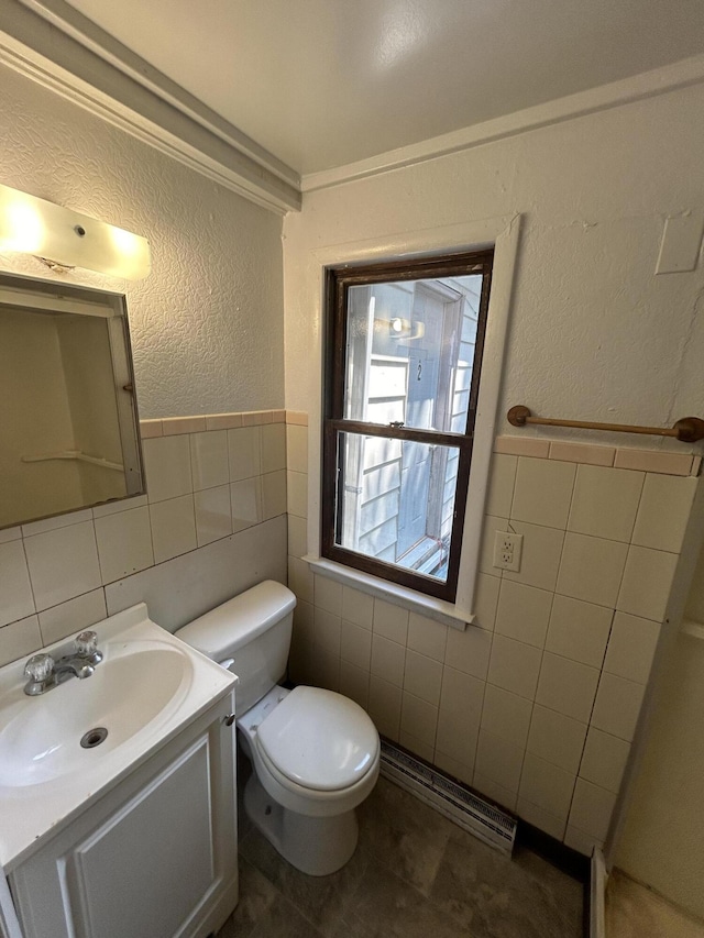 bathroom with vanity, tile walls, and toilet