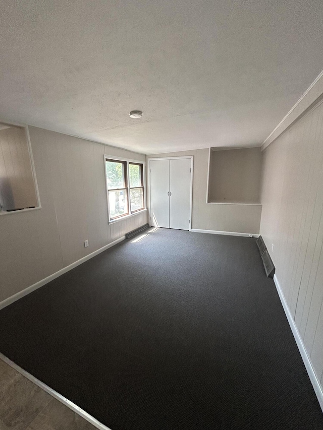 carpeted spare room featuring a textured ceiling