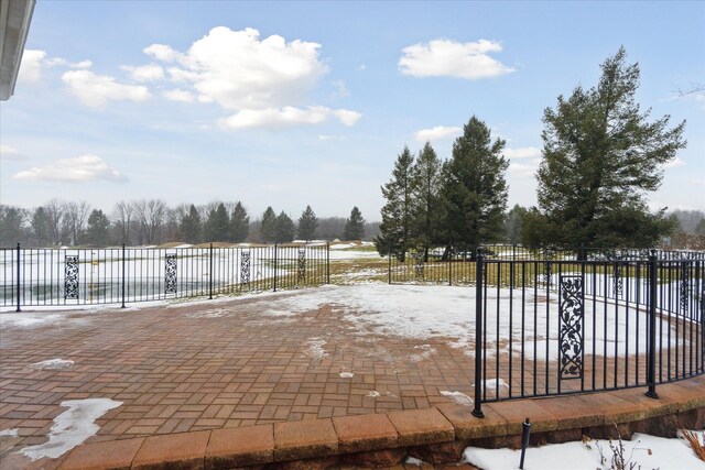 snow covered patio featuring fence