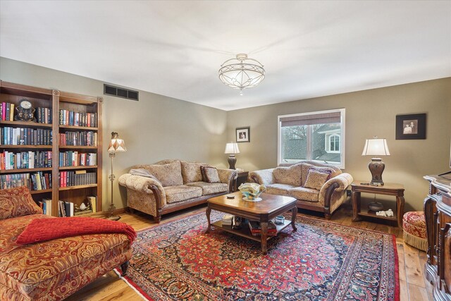 living area with visible vents and wood finished floors