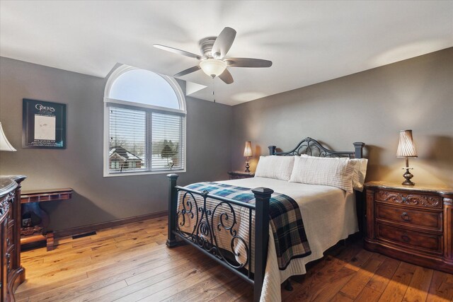 bedroom featuring baseboards, ceiling fan, vaulted ceiling, and hardwood / wood-style flooring