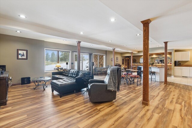 living room with recessed lighting, baseboards, light wood-style floors, and ornate columns