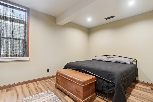 bedroom featuring wood finished floors, visible vents, baseboards, recessed lighting, and beamed ceiling