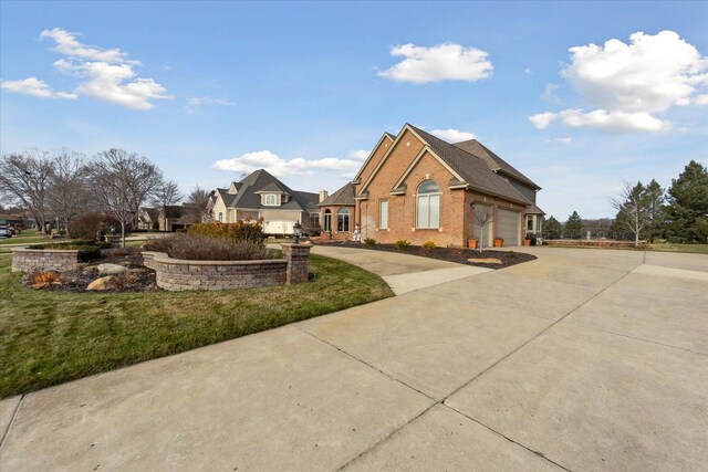 exterior space with a yard, brick siding, concrete driveway, and an attached garage