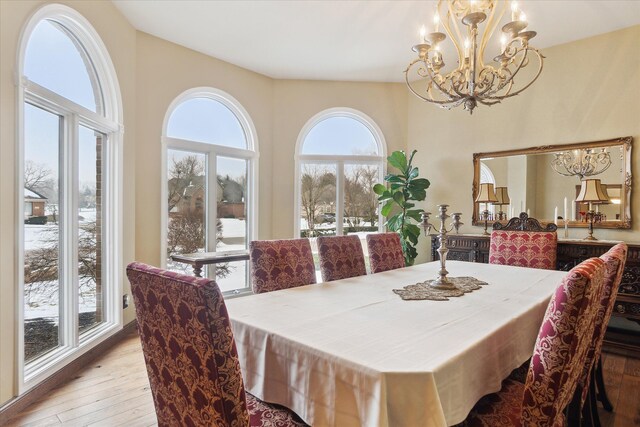 dining space featuring a notable chandelier, plenty of natural light, and hardwood / wood-style flooring