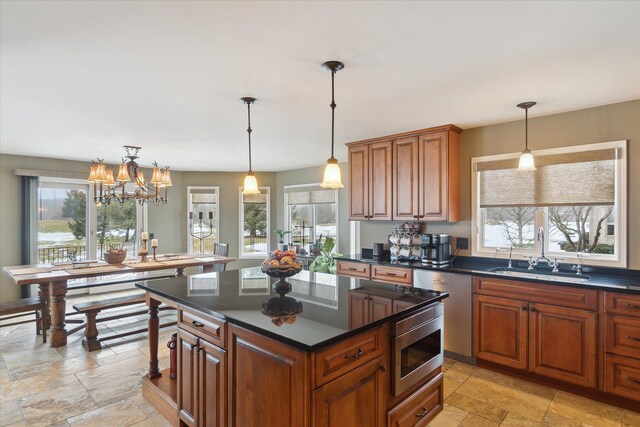 kitchen with stone tile flooring, a center island, stainless steel appliances, and a sink