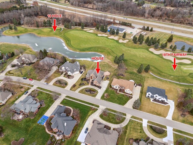 birds eye view of property with view of golf course, a water view, and a residential view