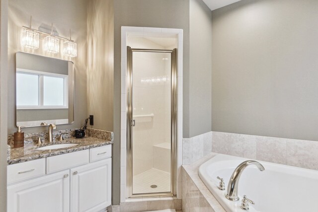 bathroom featuring vanity, a bath, and a stall shower