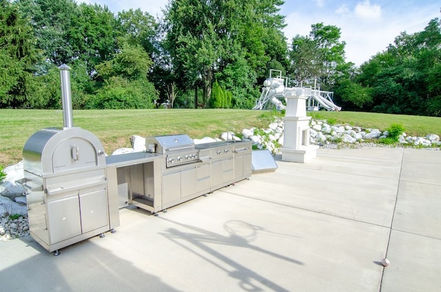 view of patio featuring area for grilling and a playground