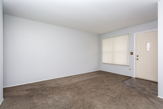 entrance foyer featuring dark colored carpet