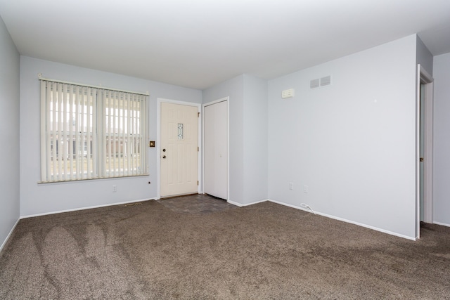 unfurnished room with dark colored carpet