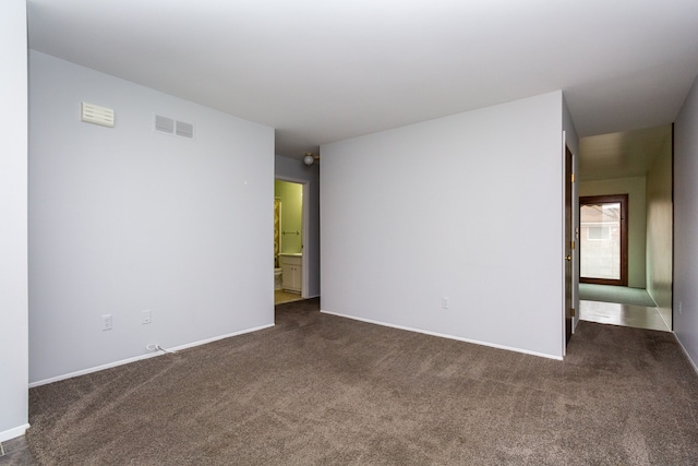 unfurnished room with dark carpet