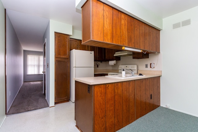 kitchen with tasteful backsplash, white appliances, and kitchen peninsula