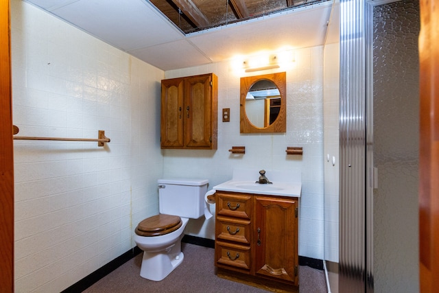 bathroom with tile walls, vanity, and toilet