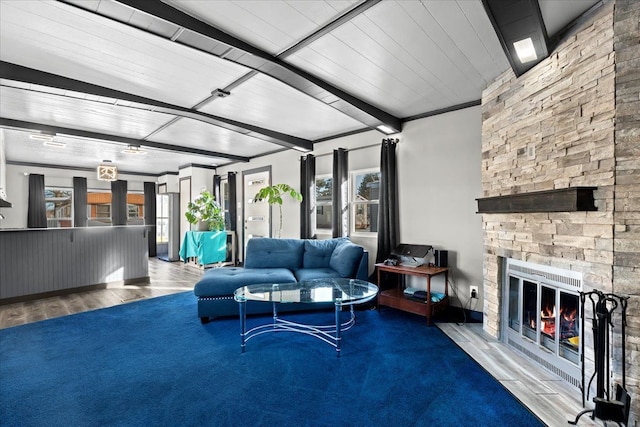 living room featuring hardwood / wood-style flooring, plenty of natural light, a fireplace, and beamed ceiling