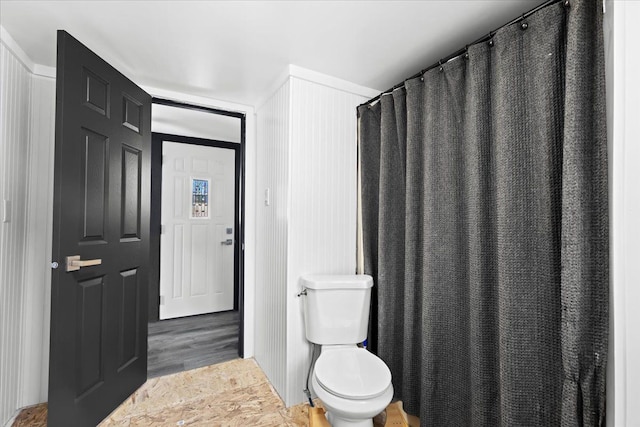 bathroom with curtained shower, wood-type flooring, and toilet