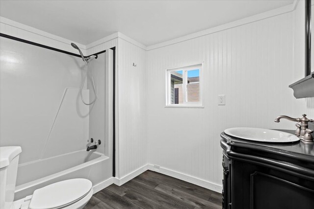 bathroom featuring toilet, wood finished floors, bathing tub / shower combination, vanity, and baseboards