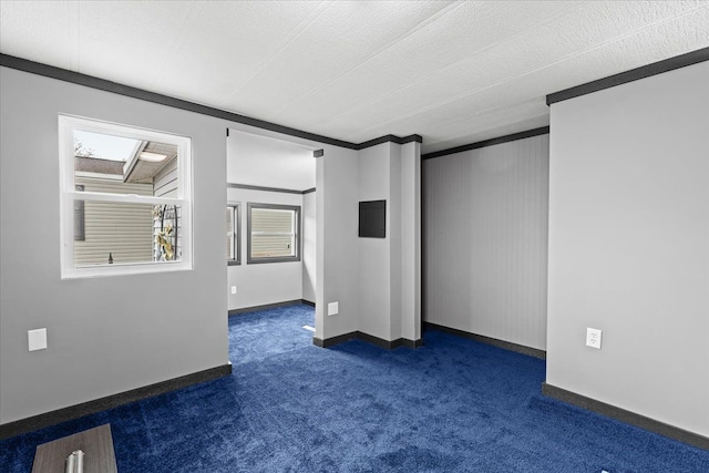 empty room featuring dark colored carpet and baseboards