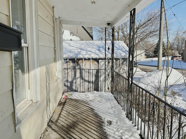 view of snow covered back of property