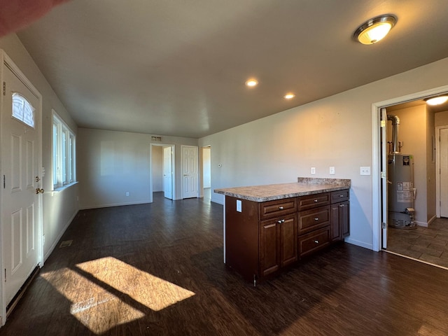 kitchen featuring dark hardwood / wood-style flooring, gas water heater, and dark brown cabinetry