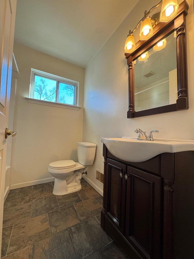 bathroom featuring vanity, toilet, and vaulted ceiling