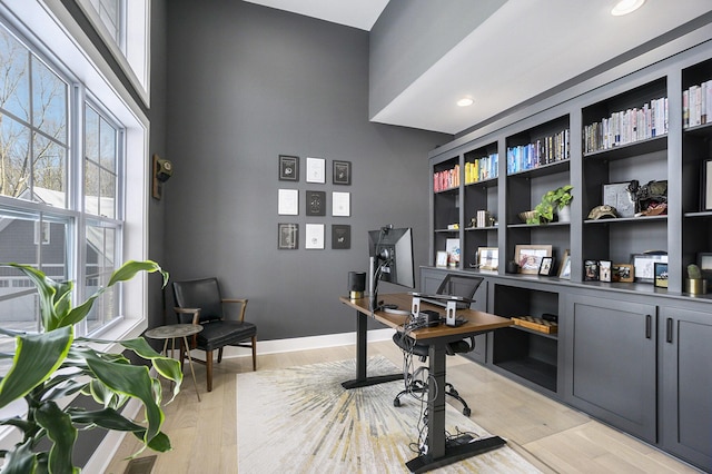 home office with light hardwood / wood-style flooring