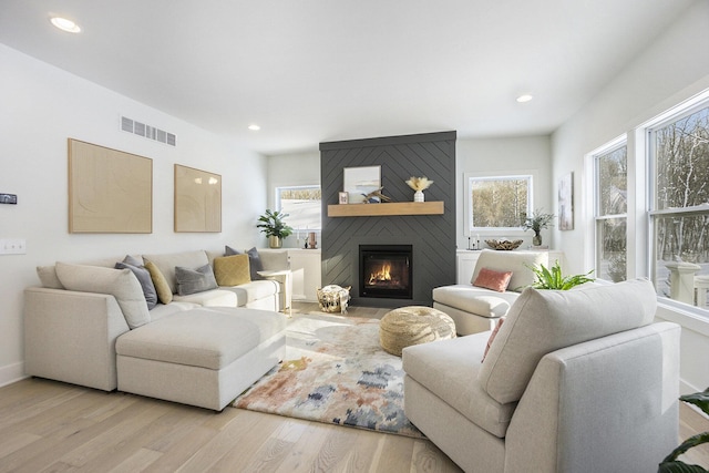 living room with light wood-type flooring and a fireplace