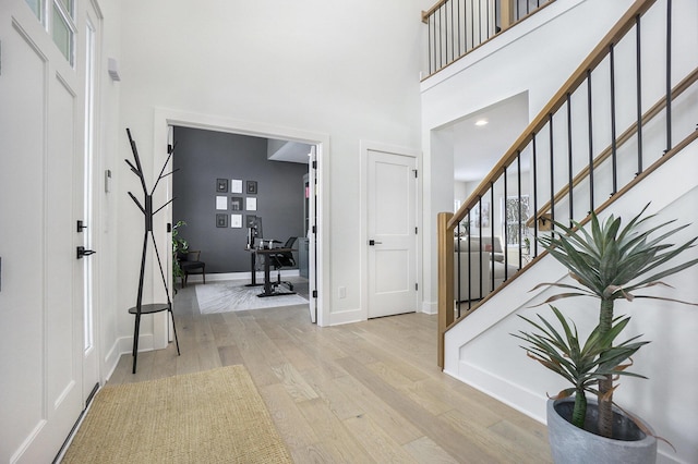 entryway featuring light hardwood / wood-style flooring and a high ceiling