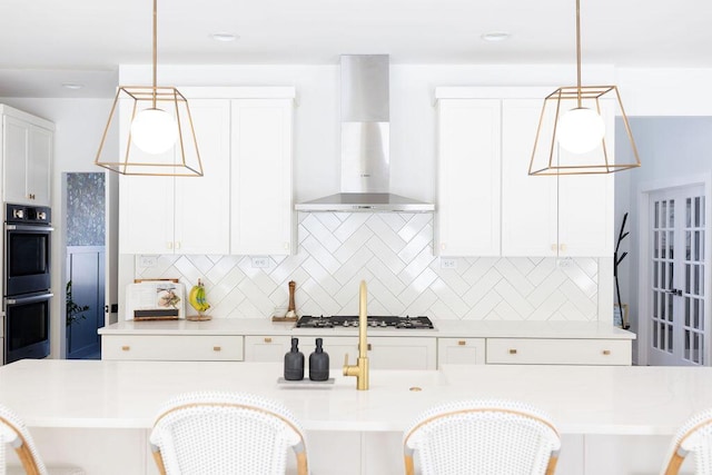 kitchen featuring pendant lighting, a breakfast bar, and wall chimney exhaust hood