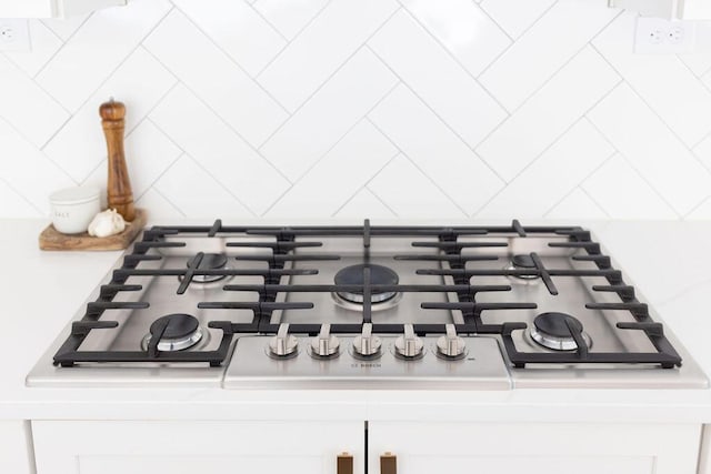 room details featuring white cabinetry, gas cooktop, and tasteful backsplash