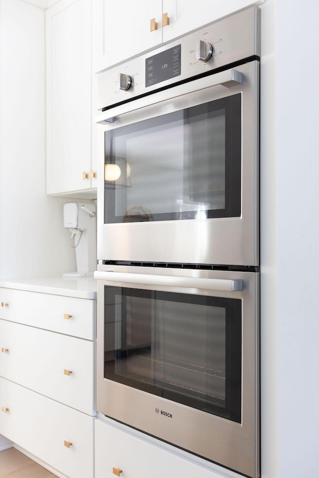 kitchen featuring white cabinetry and stainless steel double oven