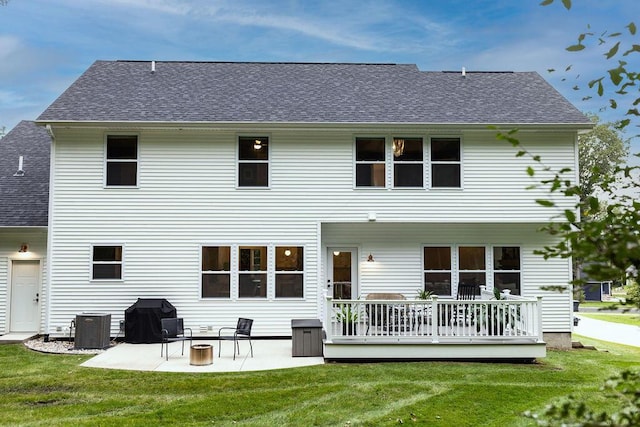 rear view of property featuring cooling unit, a patio, a wooden deck, and a lawn