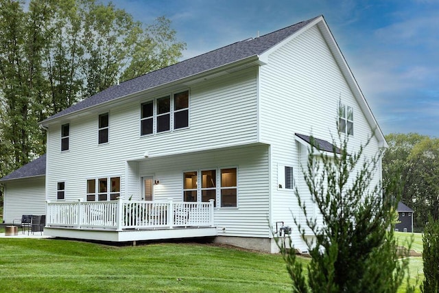 rear view of property with a wooden deck and a yard