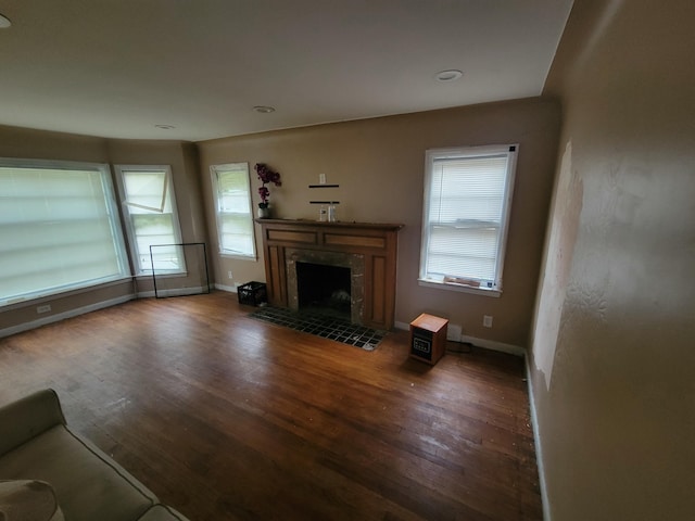 unfurnished living room with a premium fireplace and dark hardwood / wood-style floors