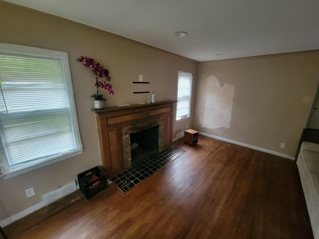 unfurnished living room with dark hardwood / wood-style flooring and a fireplace