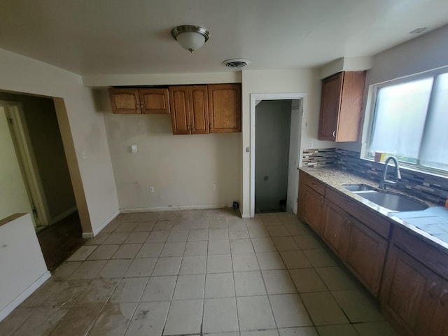 kitchen featuring light tile patterned flooring, sink, and decorative backsplash