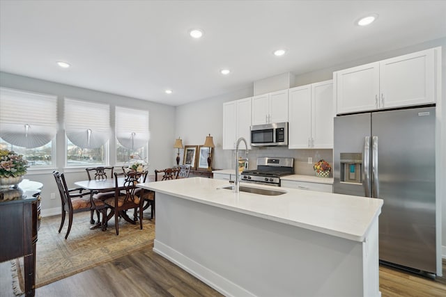 kitchen featuring white cabinetry, an island with sink, appliances with stainless steel finishes, and dark wood-type flooring