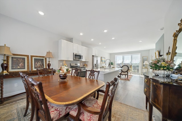 dining area featuring sink and light wood-type flooring