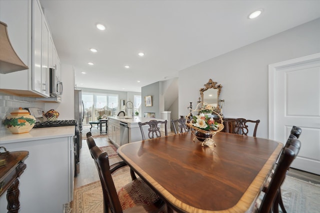 dining room with sink and light hardwood / wood-style flooring