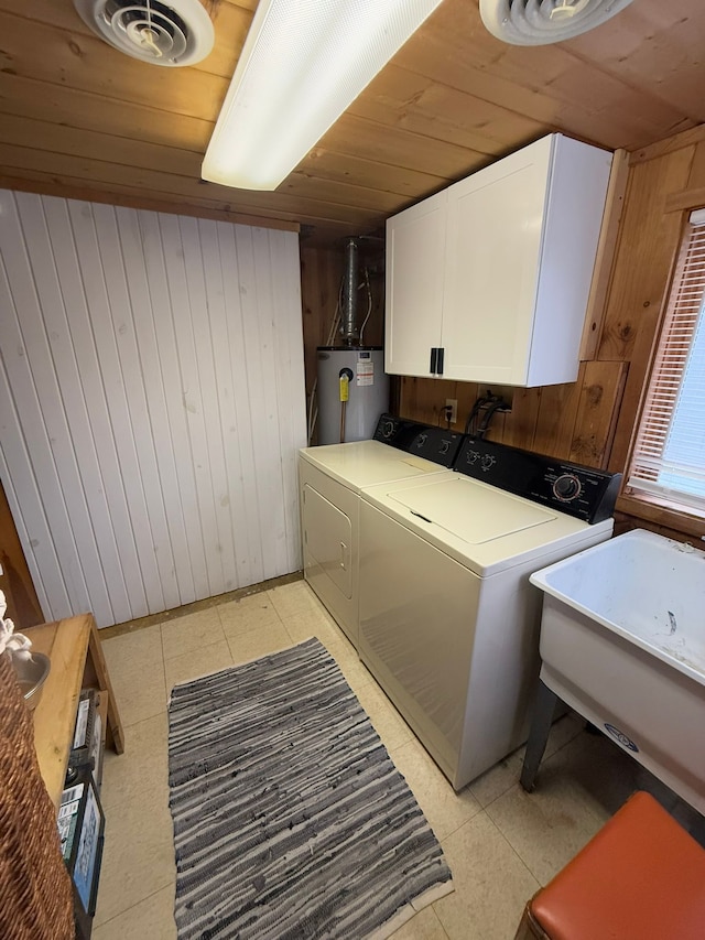 washroom featuring wooden walls, water heater, separate washer and dryer, cabinets, and wood ceiling