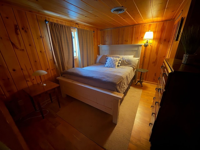 bedroom featuring wooden ceiling, light hardwood / wood-style floors, and wood walls