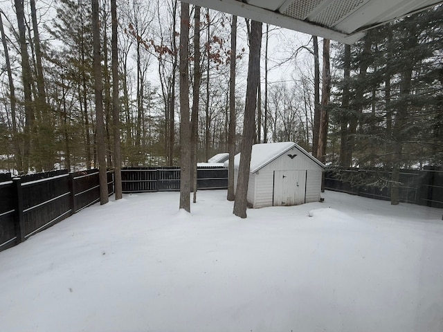 yard covered in snow featuring a storage shed