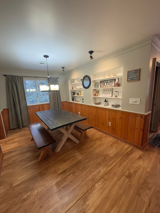 dining area with crown molding and light wood-type flooring